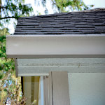 Beige seamless gutter slightly longer that roof to catch more runoff