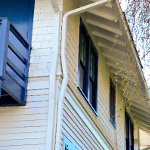 Multi level historic building's gutter and downspout wrapping around the buildings trim